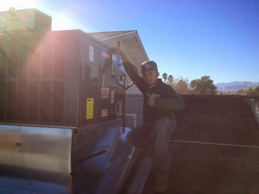 HVAC technician performing Boiler Repair on a rooftop unit in Winfield