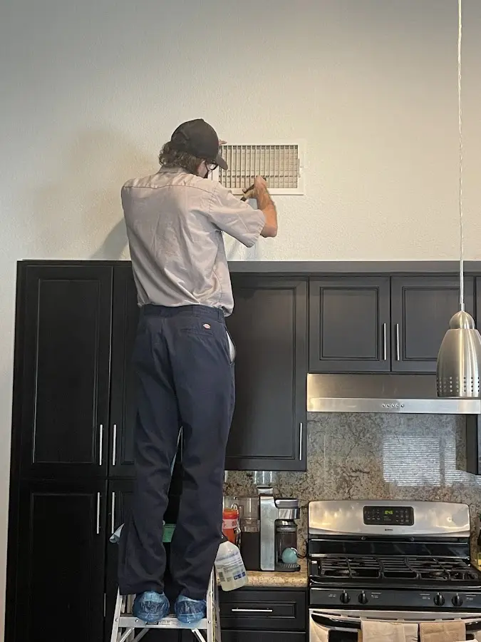 Technician inspecting an air vent during HVAC service in Winfield